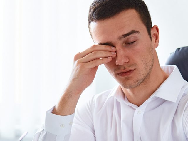 man rubbing eyes due to dry eyes